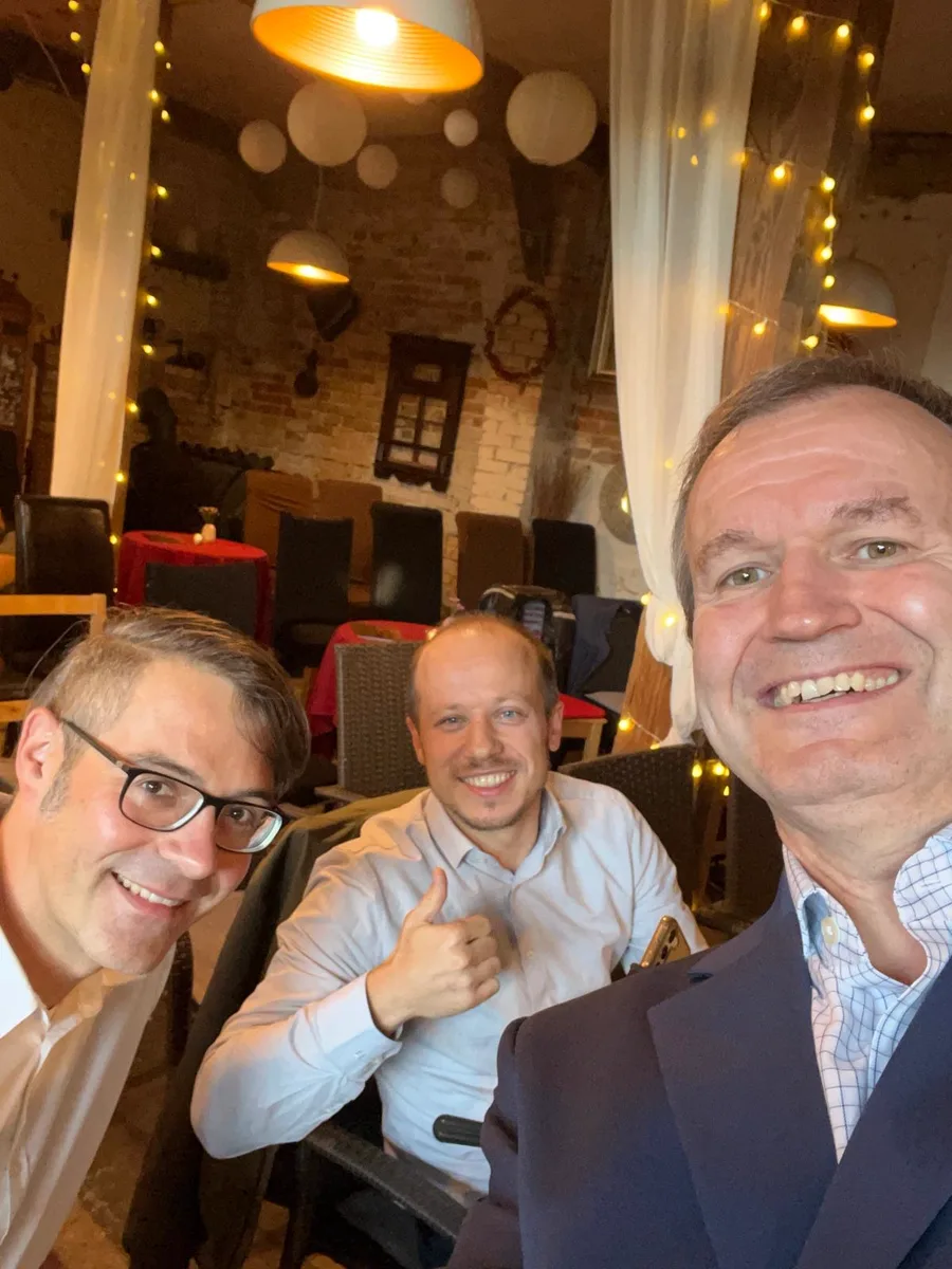 Drei Mitglieder der Wirtschaftsjunioren im Gespräch an einem Tisch in gemütlicher Runde.